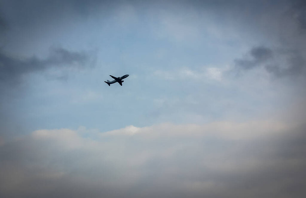 Το αεροπλάνο ανεβαίνει στο γαλάζιο συννεφιασμένο ουρανό, την αρχή του ταξιδιού στο εξωτερικό - Φωτογραφία, εικόνα
