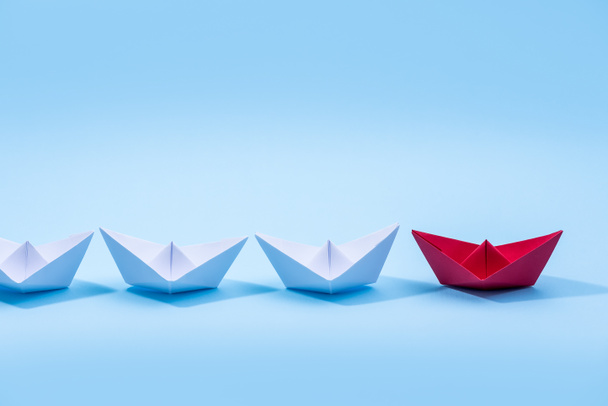 Barcos de papel rojo y blanco. Concepto de embarcaciones de liderazgo para grupo de trabajo en equipo o éxito. - Foto, imagen