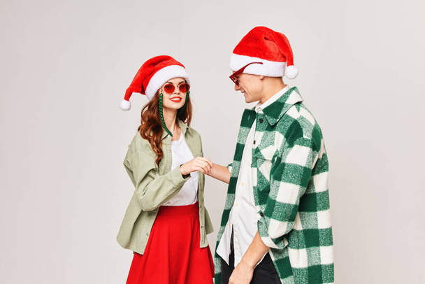 young couple in sunglasses in santa hat hug friendship holiday - Photo, Image