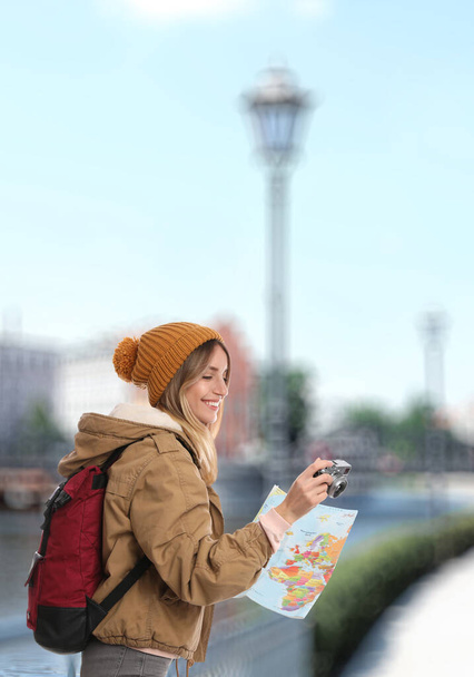 Happy traveler with camera and map in foreign city. Vacation trip - Фото, изображение