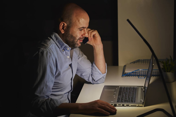 Un entrepreneur indépendant travaillant à domicile avec un ordinateur portable. Homme chauve adulte - Photo, image