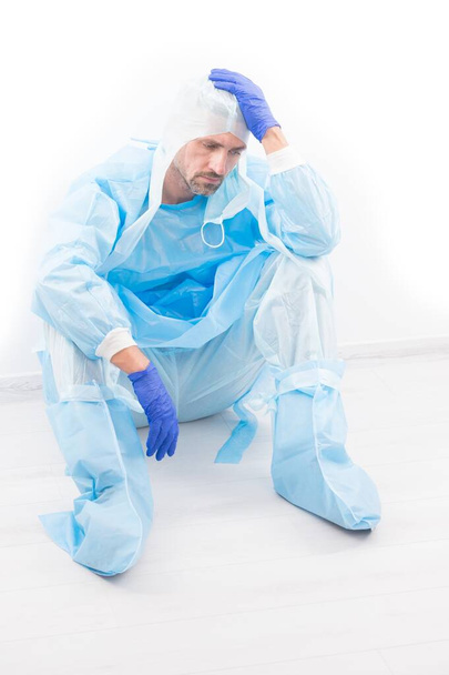 exhausted man doctor epidemiologist has headache in safety protective costume on coronavirus pandemic quarantine isolated on white, lab medical worker - Foto, Imagen
