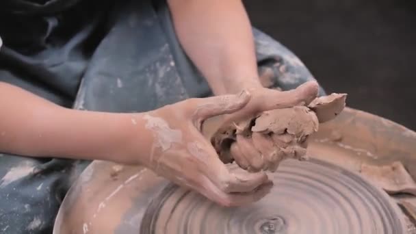 Il maestro-ceramista crea una pentola di argilla su una ruota di vasai. Mani di vasaio da vicino. Artigianato antico e ceramica lavoro fatto a mano - Filmati, video