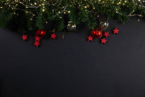 クリスマスの背景レイフラット。黒の背景に赤い星、クリスマスの装飾、フラットレイ。テキスト、雪のための場所 - 写真・画像
