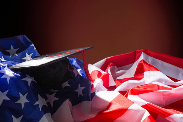Gorra de graduación con borla y cinta roja en bandera americana. - Foto, imagen