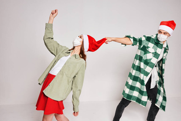 Genç çiftler Noel şapkalarını şapkalaştırır. - Fotoğraf, Görsel