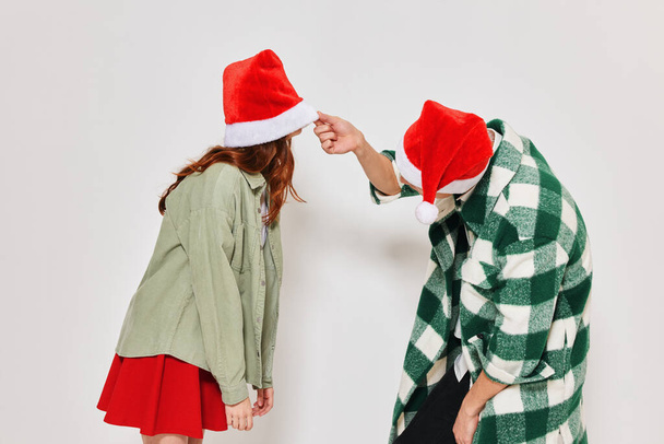 Noel şapkalı genç çift tatil stüdyosu arkadaşlığı eğlencesi - Fotoğraf, Görsel