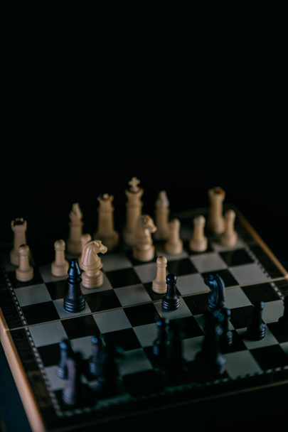 Szachy na szachownicy w ciemnym stylu. Skupienie selektywne - Zdjęcie, obraz