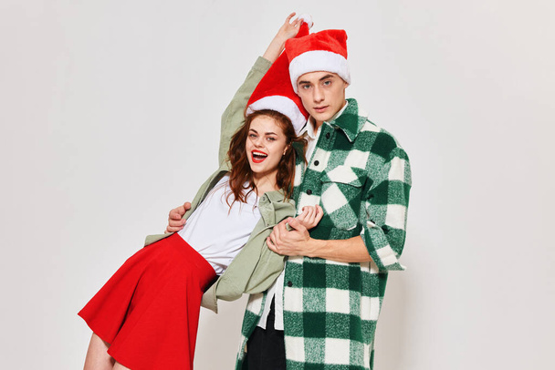 Cheerful young couple Santa hat holiday gifts lifestyle isolated background - Фото, изображение