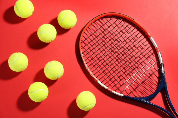 Tennis racket and balls on red background, flat lay. Sports equipment - Foto, Imagen