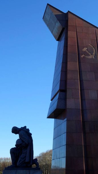 Bronzová socha klečícího vojáka se skloněnou hlavou u sovětského památníku v Berlíně - Fotografie, Obrázek