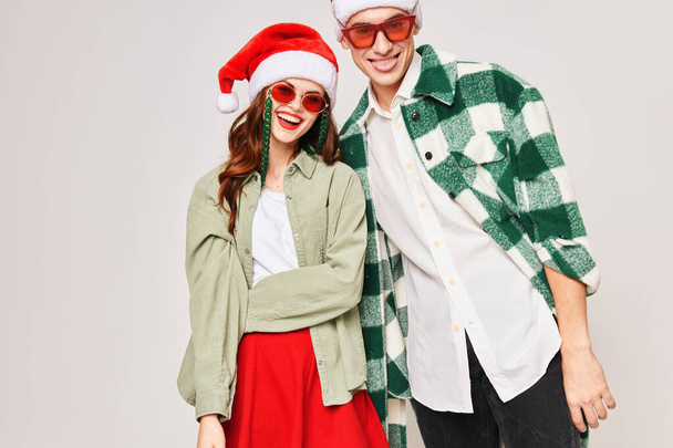 Cheerful young couple wearing black glasses for Christmas holiday close-up hug - Foto, Bild