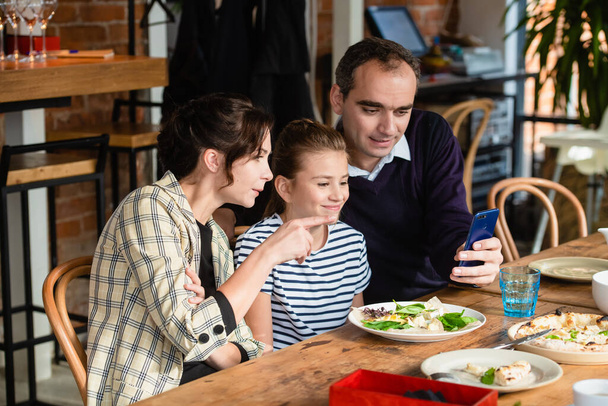 Famille de trois personnes à une table à manger prenant un selfie - Photo, image