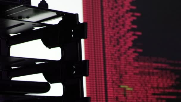 Rode computersoftware code beweegt op een zwarte monitor reflecteert op glas. Abstract computer hacken in proces met rack server base, dynamische tekst draait en stroomt op pc scherm. - Video