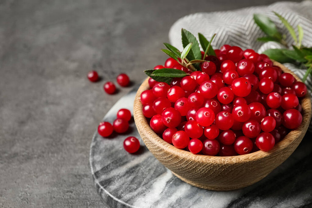 Tasty ripe cranberries on grey table, closeup. Space for text - Foto, imagen