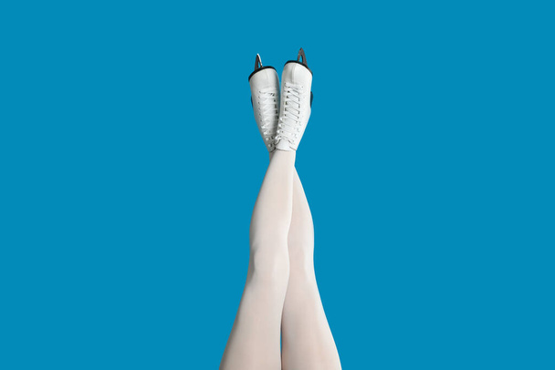 Woman in elegant white ice skates on light blue background, closeup of legs - Valokuva, kuva
