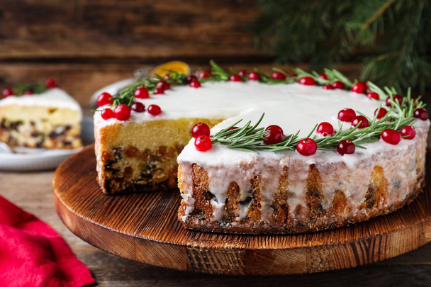 Traditional Christmas cake decorated with rosemary and cranberries on table, closeup - Valokuva, kuva