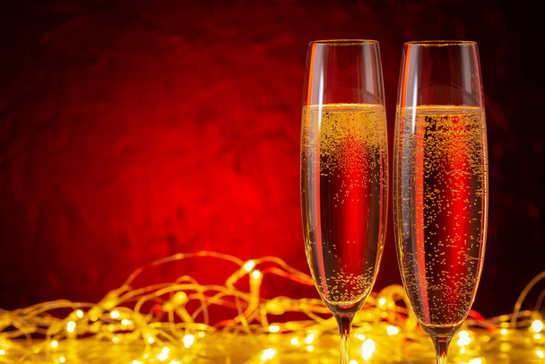  Christmas and New Year holidays background. Glasses of champagne and illuminations with copy space. - Zdjęcie, obraz