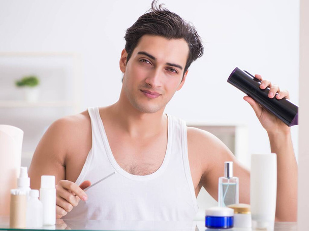 Молодий чоловік сушить волосся вранці
 - Фото, зображення