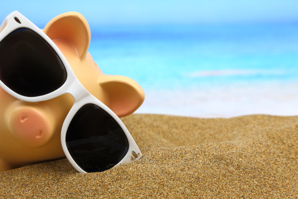 Summer piggy bank with sunglasses on the beach - Photo, Image