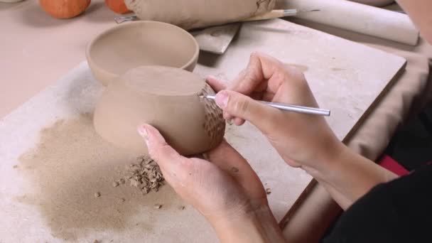 Un potier sculpte des écailles sur un bol d'argile - Séquence, vidéo