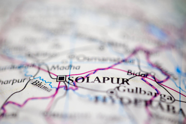 Мелкая глубина поля фокусируется на географическом расположении карты континента Солапур Индия Азия на атласе - Фото, изображение