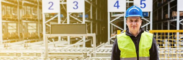 Storehouse employee in uniform working in modern automatic warehouse. Boxes are on the shelves of the warehouse. Warehousing, machinery concept. Logistics in stock. High quality photo - Φωτογραφία, εικόνα