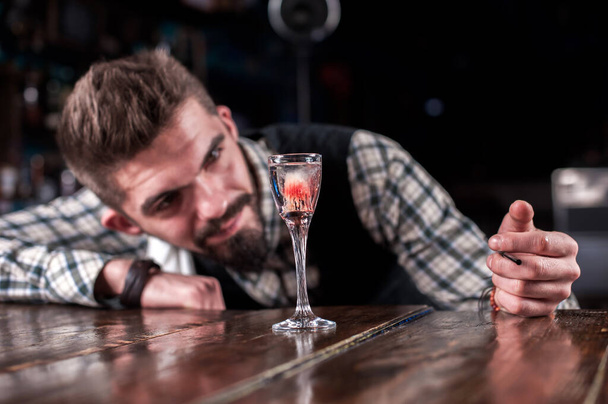 Affascinante barista mette gli ultimi ritocchi su un drink nei cocktail bar - Foto, immagini