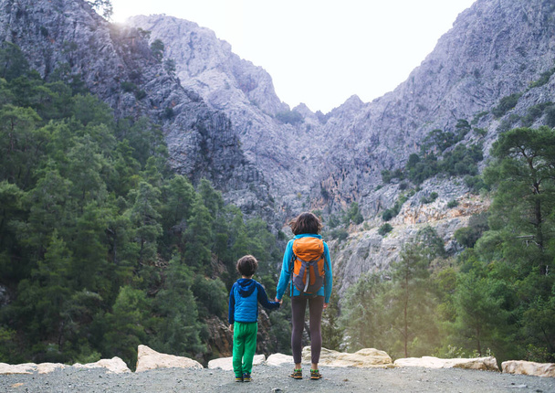 Kobieta i dziecko patrzą na wielki kanion i góry, wycieczkę z dziećmi, chłopca z matką na wędrówce, dziewczynkę z plecakiem, szlak górski. - Zdjęcie, obraz