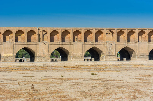 Арки моста Аллахверди-хана, также названного Ши-о-се-польским мостом, через реку Заяндеруд, в Исфахане, Иран, знаменитое историческое здание в истории Персии - Фото, изображение
