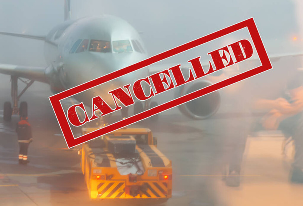 Κόκκινη απαγορευμένη πινακίδα Ακυρώθηκε, στο παρασκήνιο ένα αεροπλάνο στο αεροδρόμιο και ένας άνθρωπος αναμονής στην αντανάκλαση του γυαλιού. Η έννοια της απαγόρευσης πτήσεων και της πανδημίας του ιού. - Φωτογραφία, εικόνα