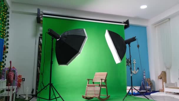 Фото или видео студия с двумя гексагоновыми огнями студии. Зеленый экран и кресло - Кадры, видео