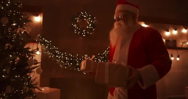 W świąteczną noc Mikołaj dostarcza prezenty do domów, kiedy wszyscy śpią. Mikołaj zostawi prezenty pod choinką w urządzonym domu - Materiał filmowy, wideo