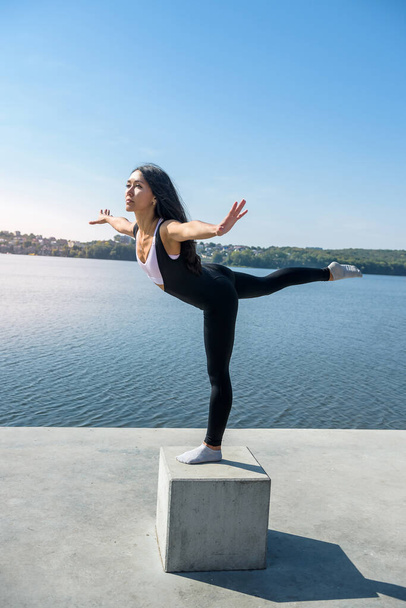Giovane donna bruna che pratica yoga la mattina presto prima dell'orario di lavoro. Concetto di benessere e stile di vita sano - Foto, immagini