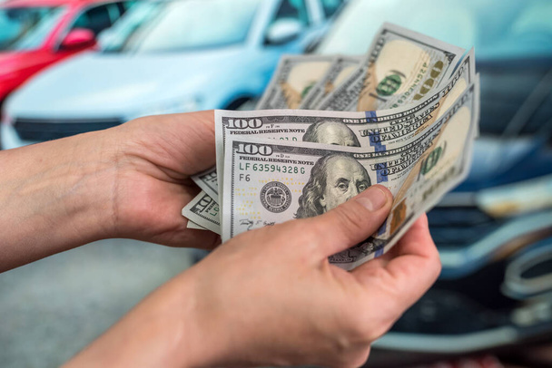 Mano masculina mostrando un dólar por comprar un coche en la autocaravana. financiación - Foto, imagen