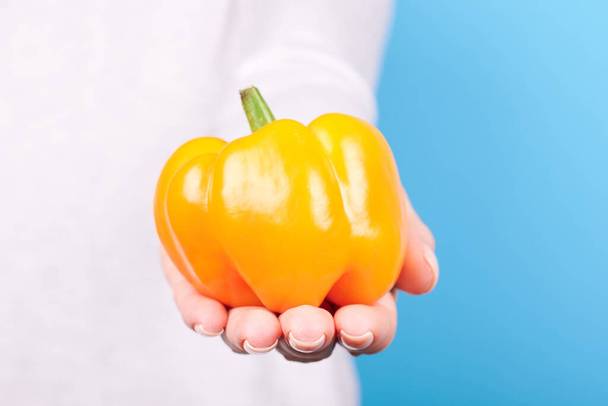 Hand with fresh ripe orange pepper. - Fotoğraf, Görsel