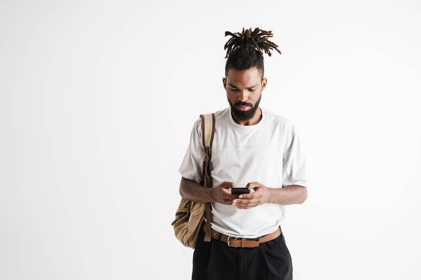 Photo of serious african american guy using mobile phone isolated over white background - Photo, Image