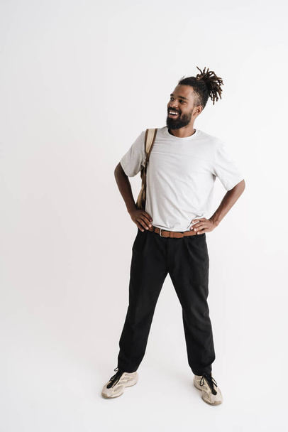Photo of joyful african american guy smiling while posing with backpack isolated over white background - Foto, afbeelding