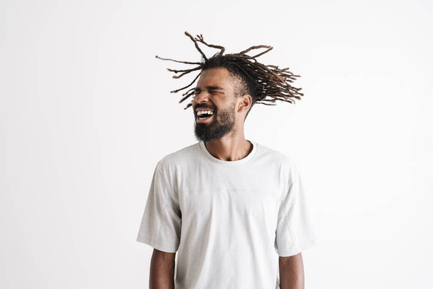 Photo of excited african american guy shaking his dreadlocks isolated over white background - Photo, image