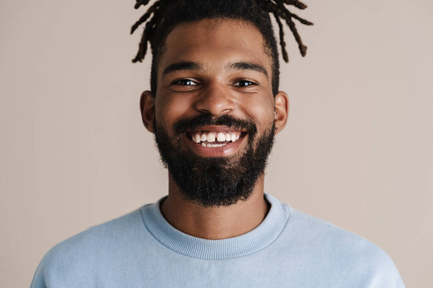Joyful african american guy smiling and looking at camera isolated over white background - Foto, afbeelding