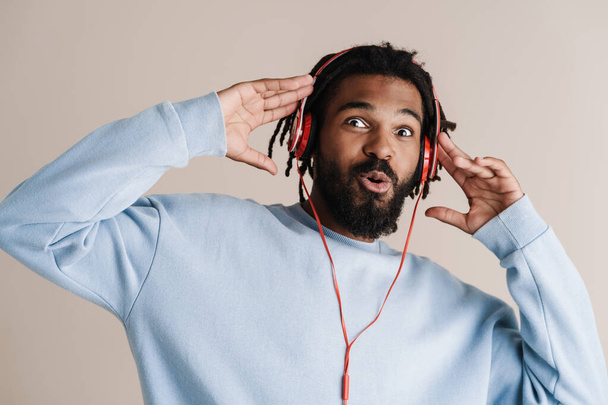 Surprised african american guy in headphones looking at camera isolated over white background - Foto, immagini