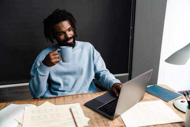 Confident young african man freelancer working at the desk - 写真・画像