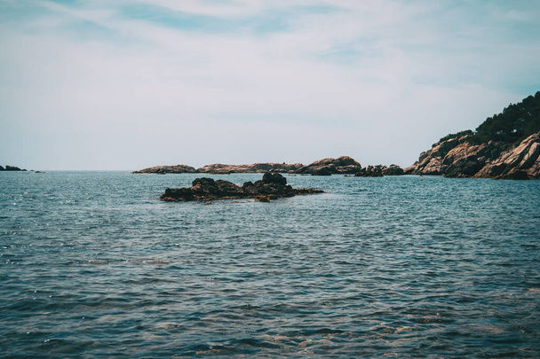 Seascape with some rocks emerging from the water in Costa Brava - 写真・画像