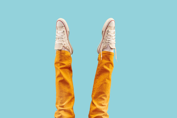 Cropped shot of white footwear, gumshoes on blue studio background - Fotografie, Obrázek