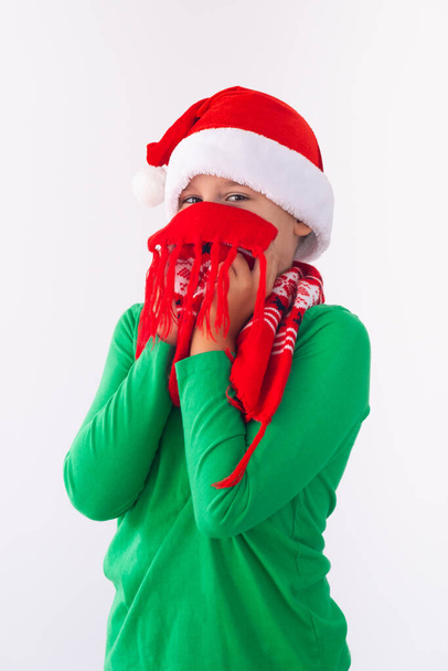 Портрет смішного хлопчика у капелюсі Санта-Клауса та зимовому шарфі. Діти розважаються на Різдво. Merry Xmas concept - Фото, зображення