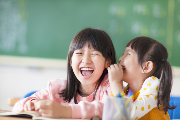 γελώντας κοριτσάκια που μοιράζονται τα μυστικά στην τάξη - Φωτογραφία, εικόνα