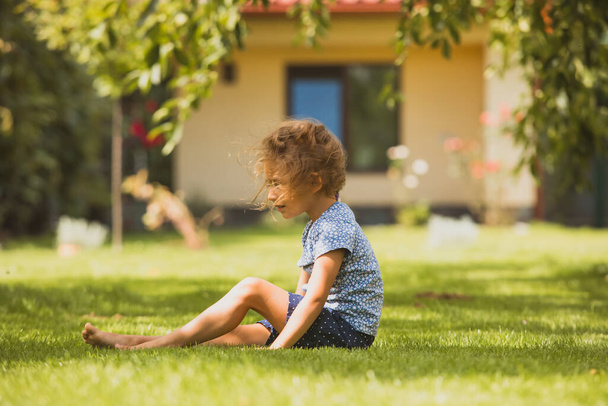 The lonely little girl in the backyard - Фото, зображення