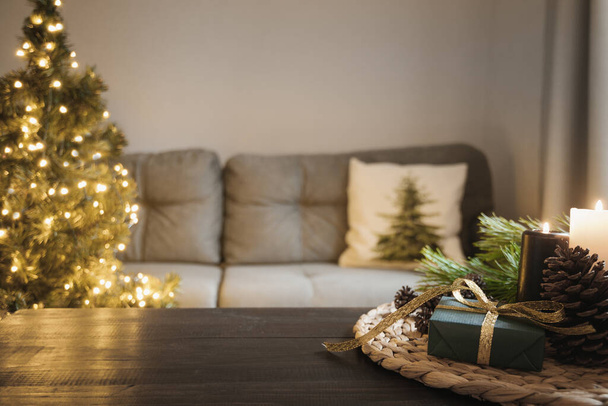 Empty wooden tabletop with candles in living room with Christmas tree. Xmas cozy holiday at home interior. - Zdjęcie, obraz