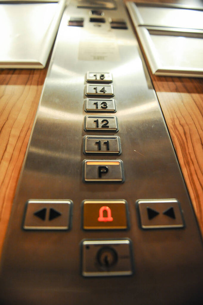 Immagine a bassa profondità di campo (messa a fuoco selettiva) con i pulsanti all'interno di un ascensore. - Foto, immagini