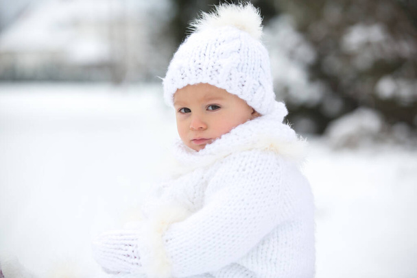 Lindo niño pequeño, jugando al aire libre con nieve en un día de invierno, nevando - Foto, Imagen